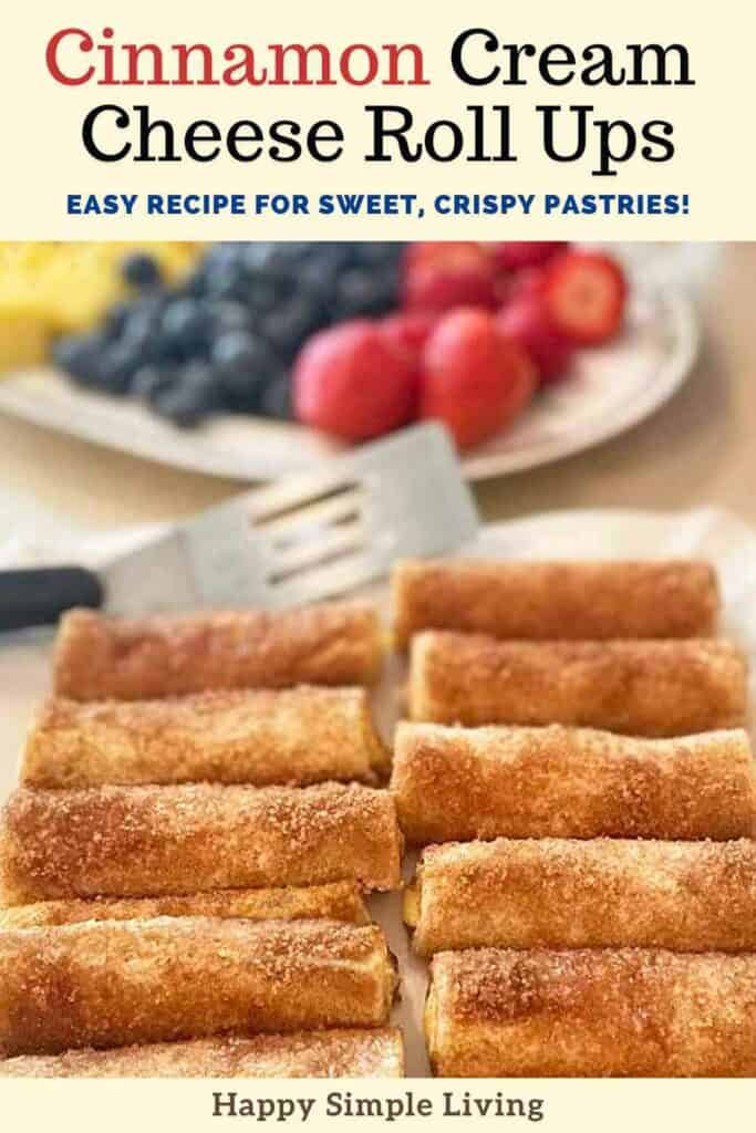 Nine cinnamon cream cheese roll ups arranged neatly on a plate. A spatula is behind them, with a blurred background of strawberries and blueberries. The text reads Cinnamon Cream Cheese Roll Ups: Easy Recipe for Sweet, Crispy Pastries!.