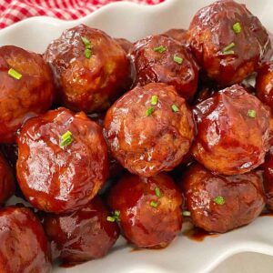Cranberry sauce meatballs sprinkled with chives, ready to serve.