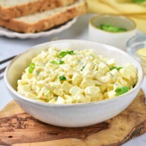 A white bowl of Southern egg salad on a cutting board.