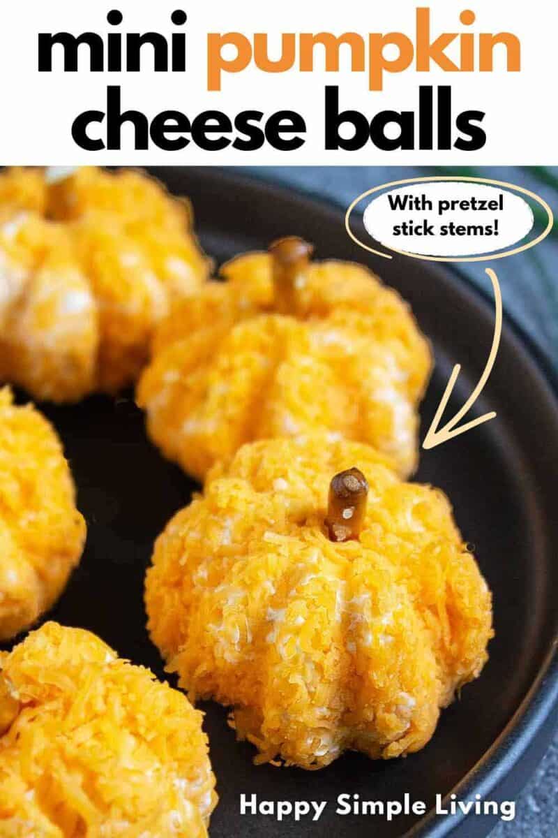 Mini pumpkin cheese balls on a black serving platter.