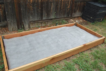 smraisedgarden2b Weed-proof fabric barrier laid on top of dirt in the raised garden.